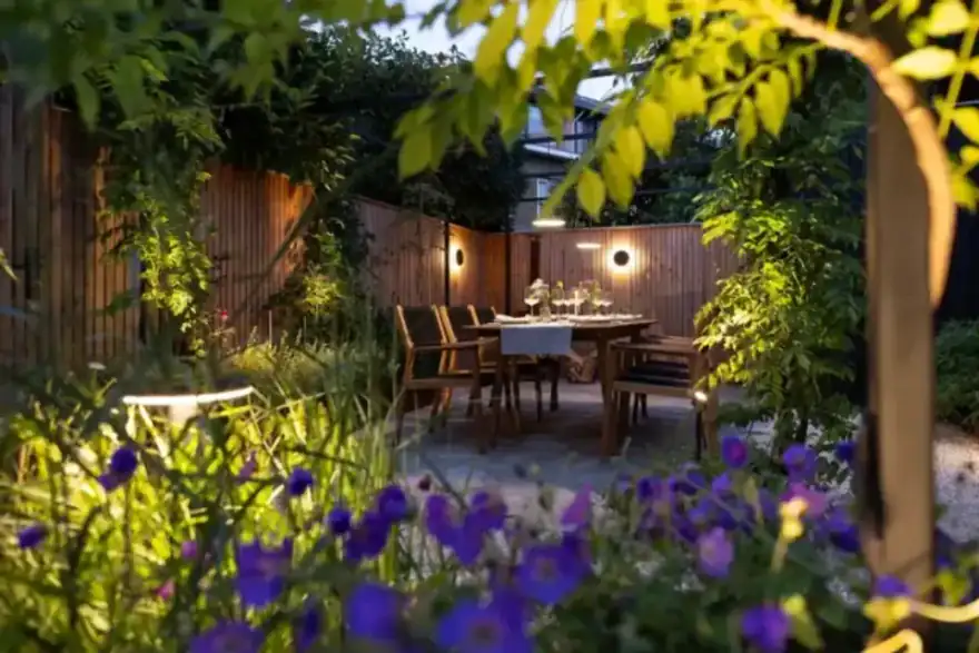 Landscaping garden with dining area and lights in a Norwich.