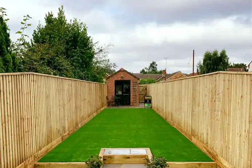A landscaped garden featuring new fencing, artificial grass and a patio by DH Landscapes