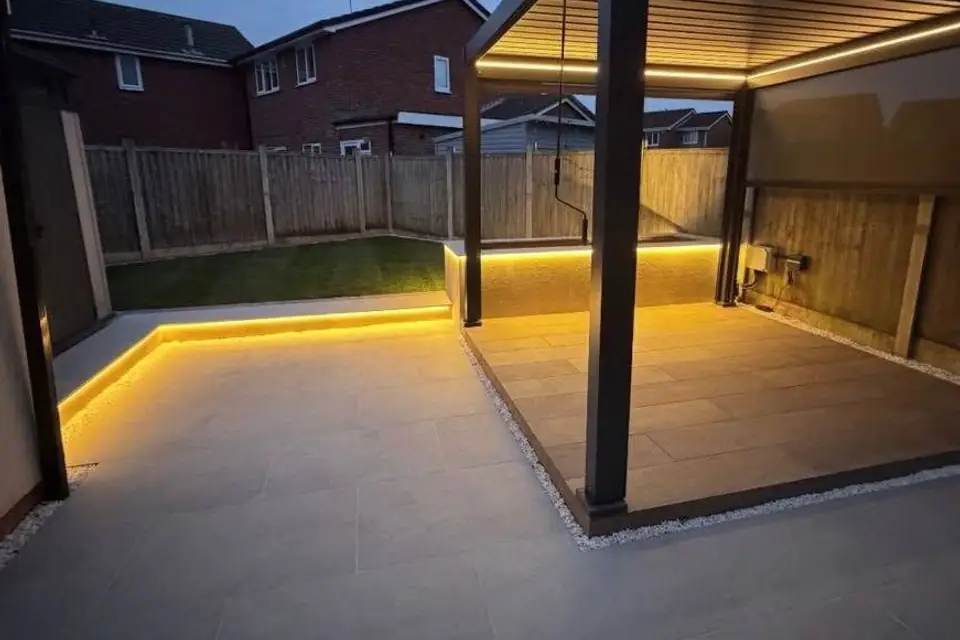 Louvred pergola with warm lighting over a porcelain patio built by GreenForge