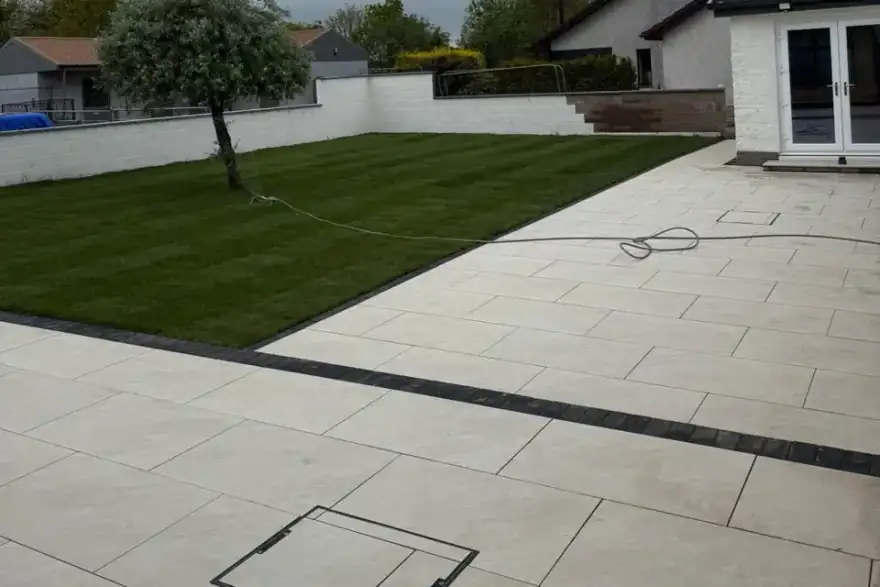 Rear-garden porcelain patio with charcoal sett detailing — Bell residence, Dornoch