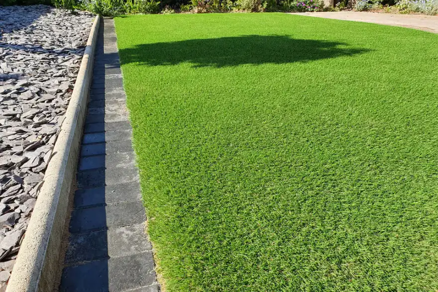 Green lawn, brick border, and slate landscape background.