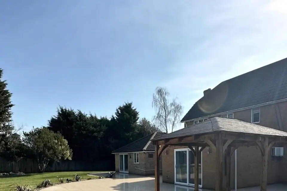 Curved porcelain patio with oak gazebo installed by landscape gardeners Belfast