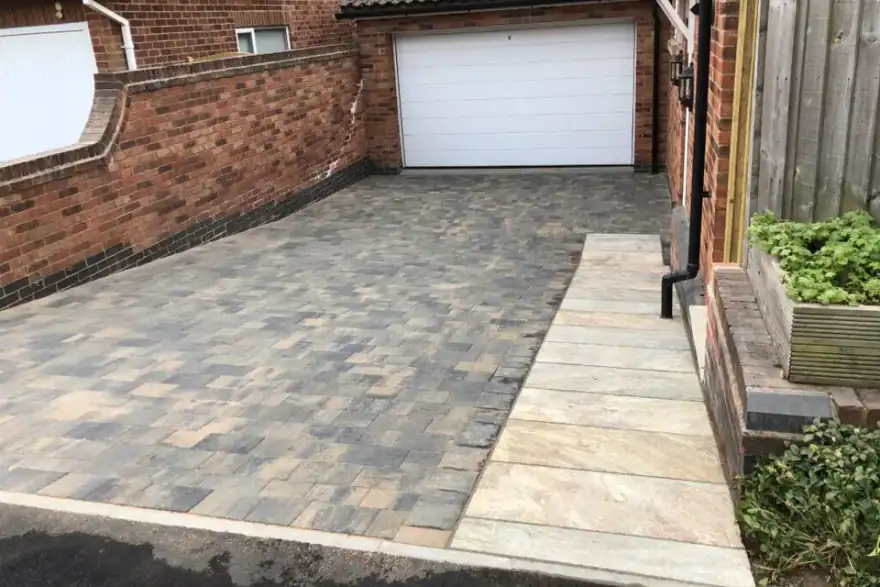 mid grey stone sloped driveway leading to garage
