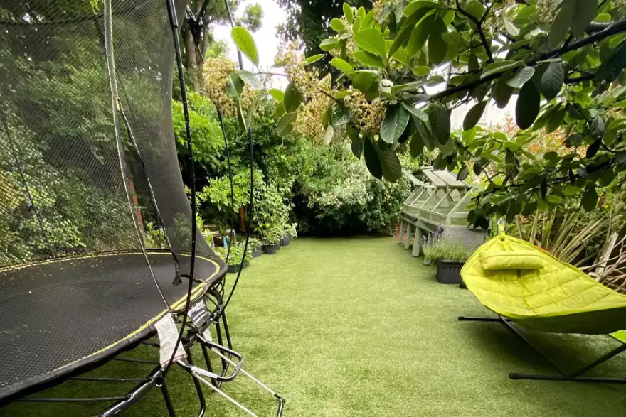 Back garden with artificial grass, trampoline and seating area