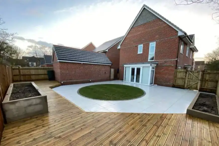 Timber decking with white patio and circular turf lawn — garden project in Reading, Berkshire