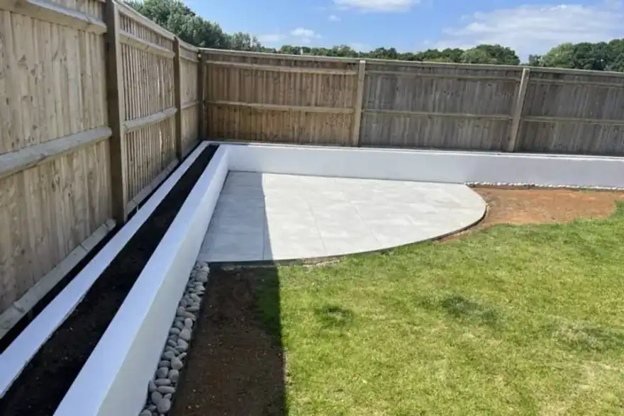 Curved porcelain patio with white raised planting beds — landscaping project in Reading