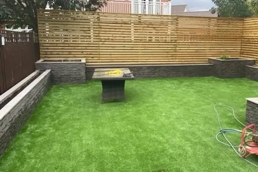 Artificial grass installation with raised planters and horizontal slatted fence — Reading, Berkshire
