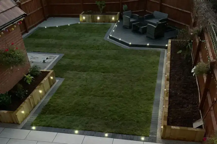 A small backyard with a lawn and lights.