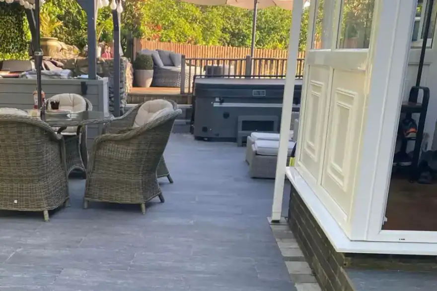 A patio with a table and chairs and an umbrella.
